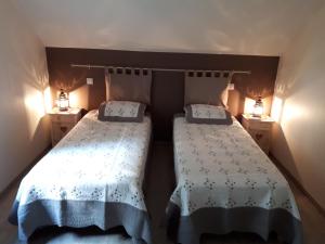 two beds in a small room with two lamps at La Basse Bédinière in Crouy-sur-Cosson