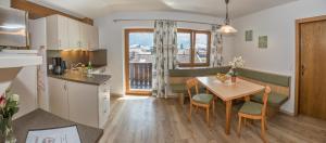 a kitchen and a dining room with a table and chairs at Appartement Schneeberger in Zell am Ziller