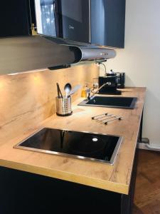 a kitchen counter with a sink and a stove at La suite Marilyn in Rouen