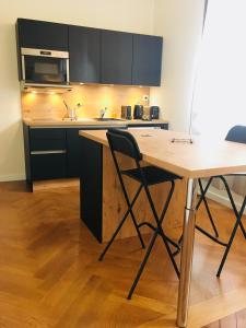 a kitchen with a wooden table and a counter top at La suite Marilyn in Rouen