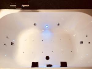 a white bath tub with black buttons on it at La suite Marilyn in Rouen