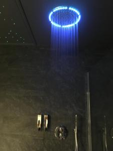 a blue light hanging from the ceiling of a shower at La suite Marilyn in Rouen