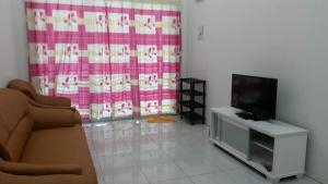 a living room with a couch and a television at Homestay Kuala Kangsar in Kuala Kangsar
