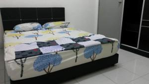a bed with a quilt and pillows on it at Homestay Kuala Kangsar in Kuala Kangsar