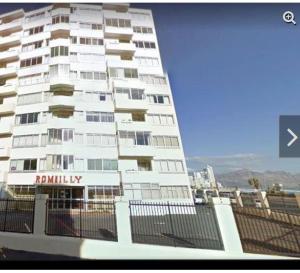 ストランドにあるRomilly Beach Apartmentの標識が書かれた白い高い建物