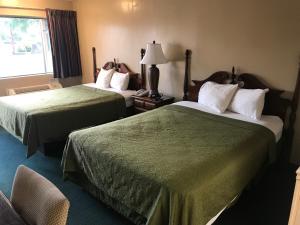 um quarto de hotel com duas camas e uma janela em Travelers inn em Bethania Station