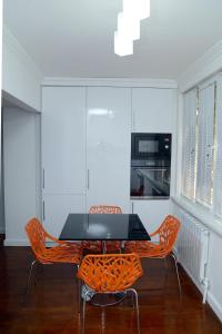 uma sala de jantar com uma mesa preta e cadeiras laranja em Apartment on Registon Kochasi em Samarkand