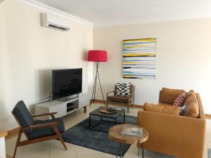 a living room with a couch and a tv at Victoria Boulevard in Vilamoura