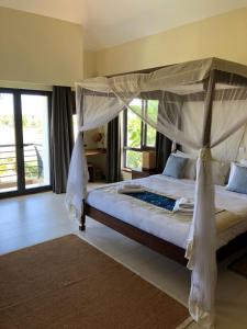 a bedroom with a large bed with a canopy at Samaki House in Kilifi