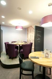 uma sala de jantar com mesas e cadeiras roxas em ibis Styles Vannes Gare Centre em Vannes