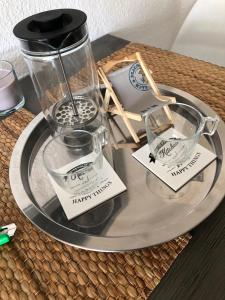 een dienblad met een koffiezetapparaat en glazen op een tafel bij „Little Hamptons“ in Grömitz