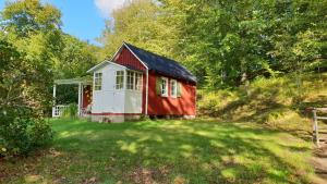 ein rotes und weißes Haus inmitten eines Gartens in der Unterkunft Stuga på Hallandsåsen in Hjärnarp