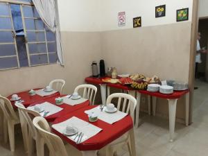 里貝朗普雷圖的住宿－Hotel Santa Marta，一间用餐室,配有两张红色的桌子和椅子