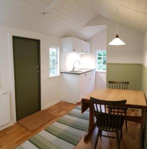 a kitchen and dining room with a table and chairs at Stuga på Hallandsåsen in Hjärnarp