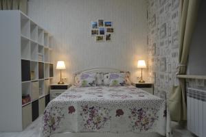 sypialnia z łóżkiem z kwiatową narzutą i 2 lampami w obiekcie Apartment at Kuznetsova Street w mieście Peresław Zaleski