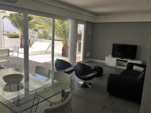 een woonkamer met een glazen tafel en stoelen bij Villalia Patricia in Playa Blanca