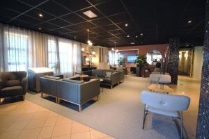 a waiting room with couches and chairs in a lobby at Comfort Hotel Arctic in Luleå