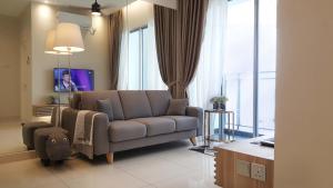 ein Wohnzimmer mit einem Sofa und einem TV in der Unterkunft SkyHabitat Johor Bahru Town City Square in Johor Bahru