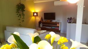 a living room with a white couch and yellow flowers at B&B Santo Stefano in Verona