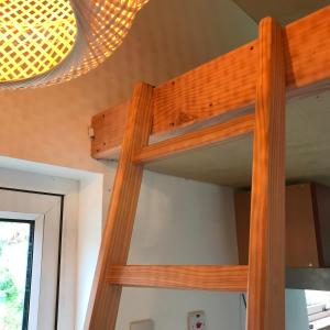 a wooden bunk bed in a room with a chandelier at Goleen Harbour Tiny House in Goleen