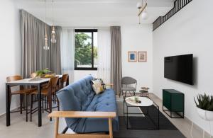 a living room with a blue couch and a table at Mr. Ben Yehuda - By TLV2GO in Tel Aviv