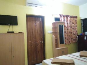 a bedroom with a bed and a wooden door at Casa De Olga in Vagator