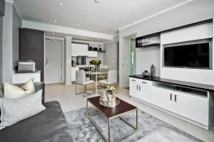 a living room with a couch and a tv at SANDTON APARTMENT MASINGITA TOWERS 15 WEST Rd SOUTH in Johannesburg
