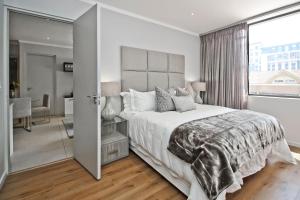 een slaapkamer met een groot bed en een groot raam bij SANDTON APARTMENT 15 WEST ROAD SOUTH in Johannesburg
