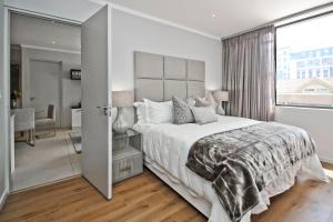 a bedroom with a large bed and a large window at SANDTON APARTMENT MASINGITA TOWERS 15 WEST Rd SOUTH in Johannesburg