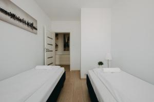 ワルシャワにあるShortStayPoland Krakowska (B65)の白い壁の客室内のベッド2台