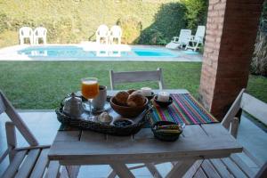 una mesa de picnic con una bandeja de comida y zumo de naranja en Casa Los Sauces en Yerba Buena
