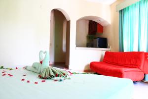 1 dormitorio con 1 cama y 1 sofá rojo en Beach Balance, en Playa del Carmen