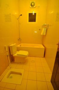 a bathroom with a toilet and a tub and a sink at Ritan Apart-Hotel in Taif