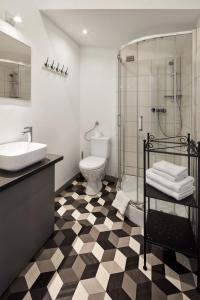 a bathroom with a sink and a shower and a toilet at Loft Piotrkowska by Good Time in Łódź