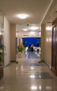 a hallway of a building with a person in the distance at Park Hotel Ermitage Resort & Spa in Lido di Jesolo