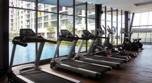 a row of treadmills in a gym with a pool at Vivacity jazz suite 3 condo 139 in Kuching