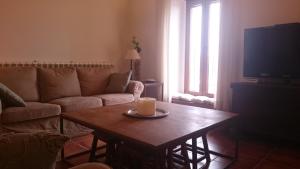 - un salon avec un canapé et une table avec une bougie dans l'établissement LAS PIÑONERAS, à Tórtoles