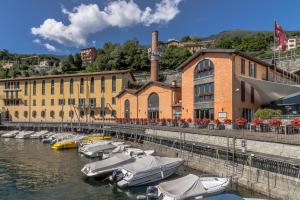 eine Gruppe von Booten, die vor einem Gebäude im Wasser angedockt sind in der Unterkunft Magnolia Musso Vista in Musso