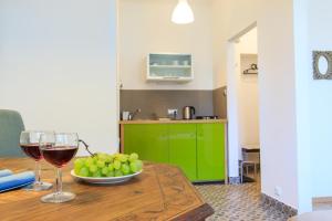 a table with two glasses of wine and a bowl of grapes at Rental Apartments Bednarska in Warsaw