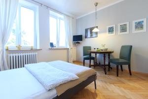 a bedroom with a bed and a table with chairs at Rental Apartments Bednarska in Warsaw