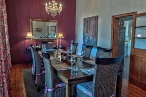 a dining room with a long table and chairs at Maison Fougere in Franschhoek