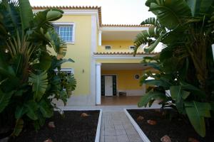 Una casa con un montón de plantas delante de ella. en Villa vista mar e piscina, en Fuseta