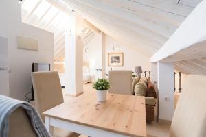 Un comedor con mesa y sillas de madera. en Loft con gran terraza en primera linea de playa, en Málaga