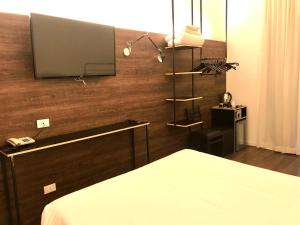 a bedroom with a tv on a wooden wall at Hotel Principe di Piemonte in Rimini
