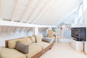 Una sala de estar con un sofá y un televisor. en Loft con gran terraza en primera linea de playa, en Málaga 12 fotos más