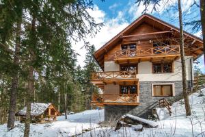 a log cabin in the woods in the snow at Chata Alpina in Ružomberok