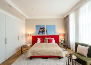 a bedroom with a large bed and a red headboard at Roosevelt Stadthaus in Vienna