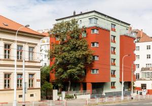 a red building with a tree in front of it at Penzion Palouček in Prague