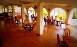 a restaurant with tables and chairs in a room at Hotel Piedras de Sol Solaris Morelos in Tlaltizapán
