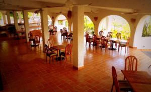 un ristorante con tavoli e sedie in una stanza di Hotel Piedras de Sol Solaris Morelos a Tlaltizapán